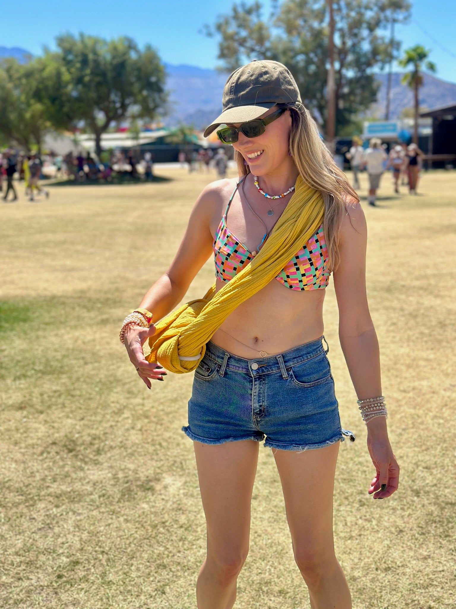SUNCHILD GOLDEN SLING USING IT TI CARRY HER WATER BOTTLE AT COACHELLA MUSIC FESTAVIL